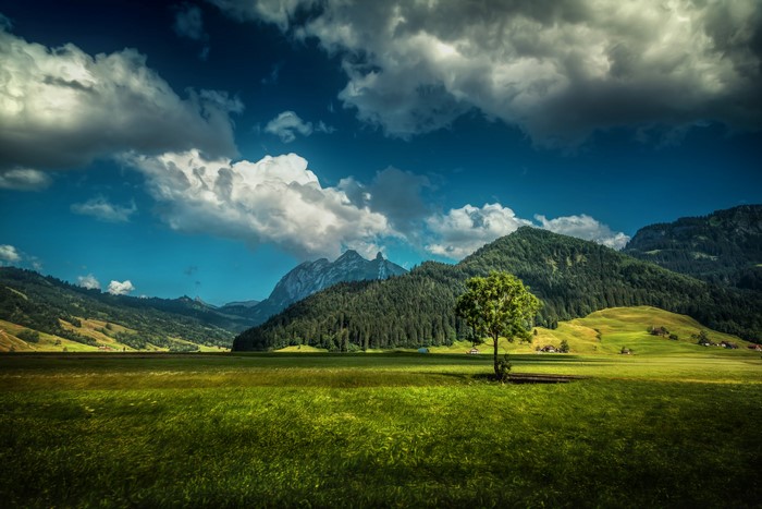 Green valley with mountains and clouds in Switzerland