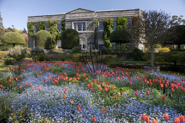 Stone mansion with formal gardens and flower beds