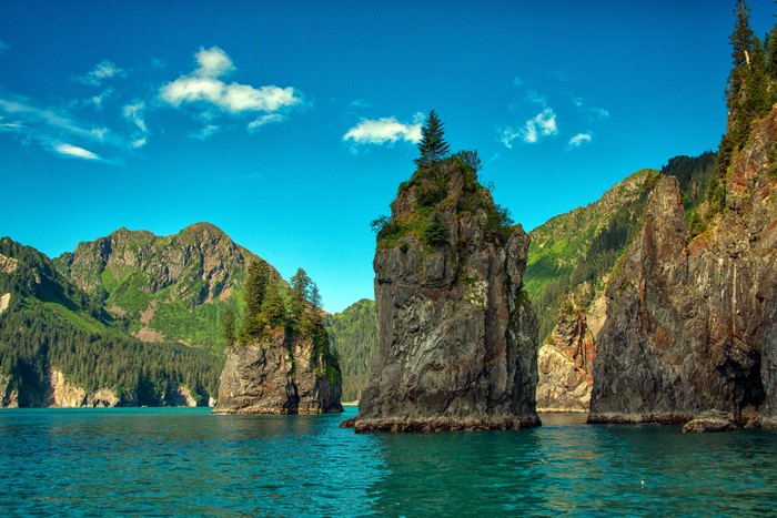 Rocky islands in a fjord with mountains and blue sky