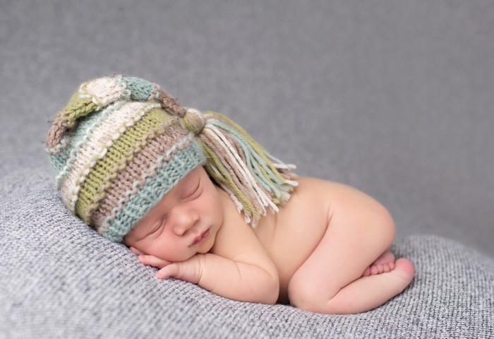 Newborn baby sleeping in a striped winter hat
