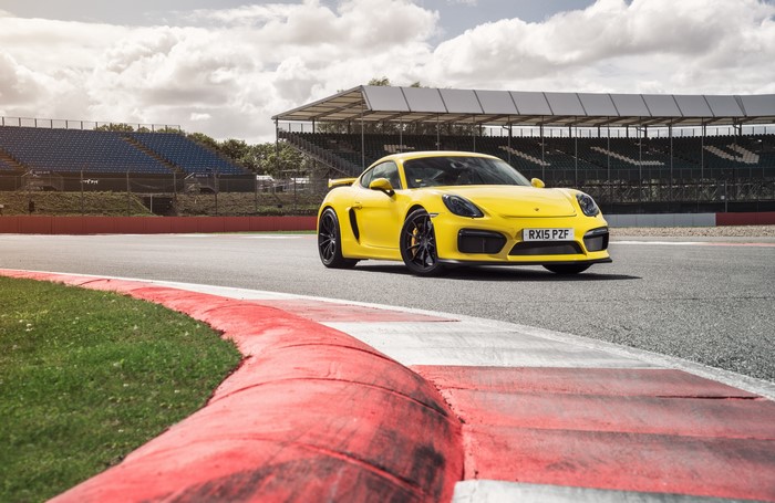 Yellow Porsche Cayman GT4 on a Race Track