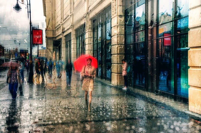 People with umbrellas walking on a rainy street in St. Petersburg