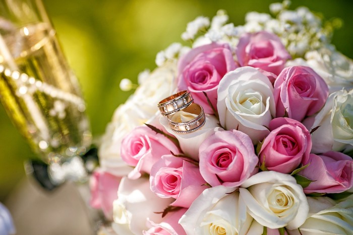 Wedding rings on a bouquet of pink and white roses
