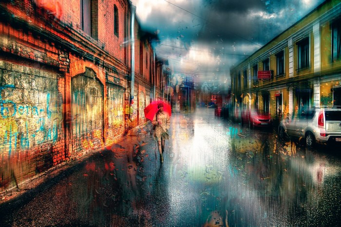 Woman with red umbrella walking on a rainy street in St. Petersburg