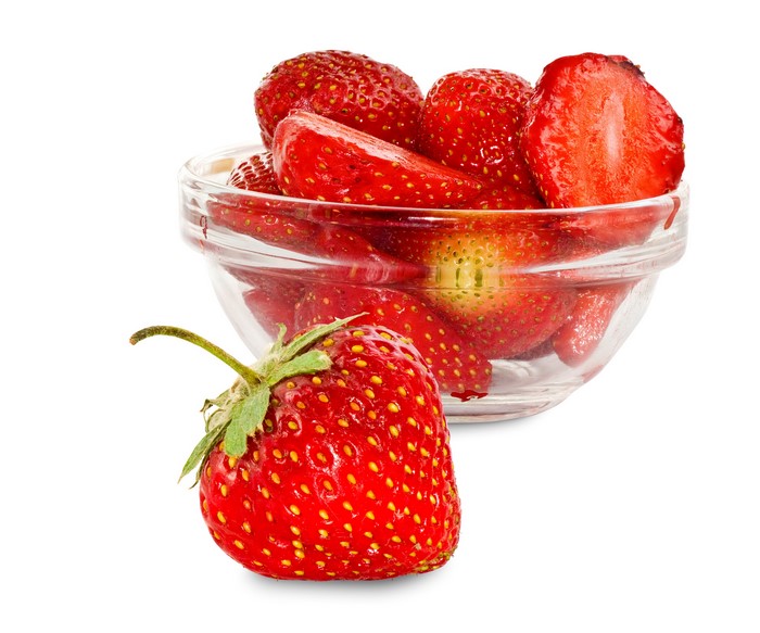 Strawberries in a glass bowl on a white background