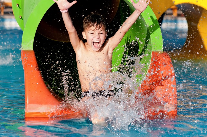 Boy splashing down a water slide