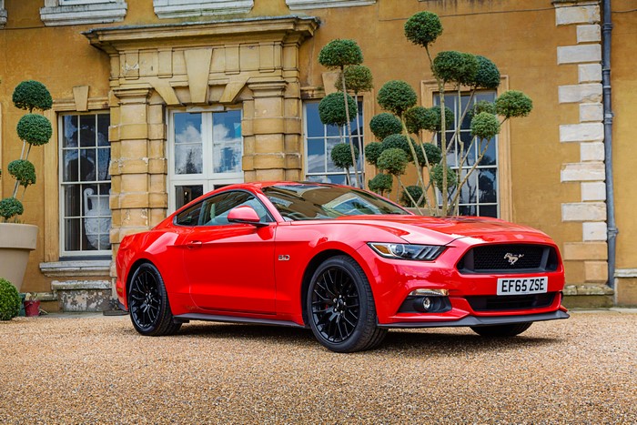 Red Ford Mustang GT parked in front of a building