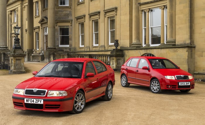 Two red Skoda cars parked in front of a building
