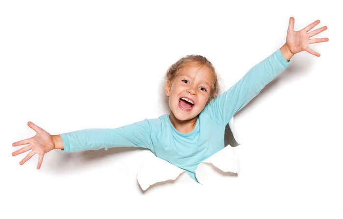 Little girl with arms outstretched through torn paper