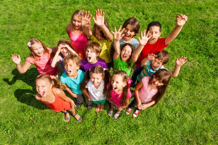 Group of Children Waving Hands on Grass