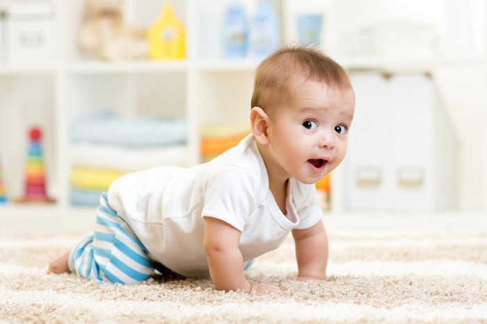 Baby boy crawling on a carpet
