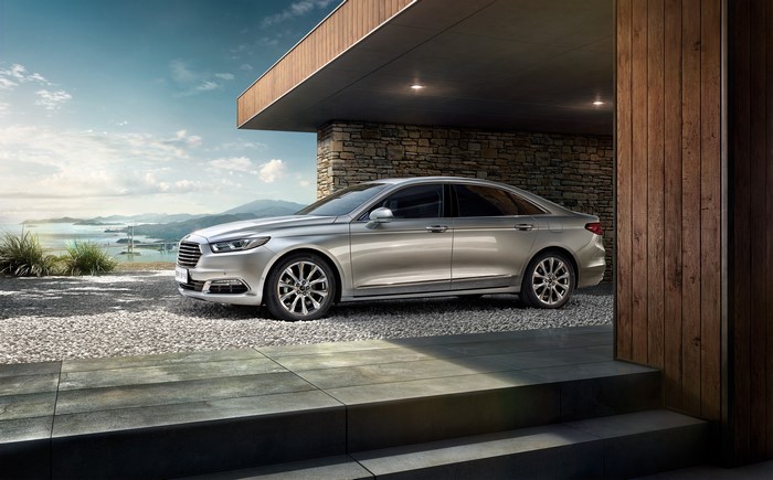Ford Taurus parked by a modern house with a scenic view