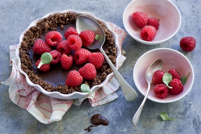 Chocolate raspberry tart with spoons and bowls