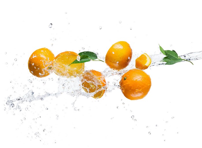 Oranges splashing in water