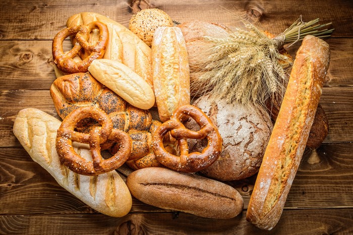 Assortment of Bread and Wheat on a Wooden Table