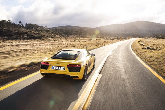 Yellow Audi R8 V10 driving on a road