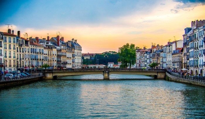 Bayonne, France: Riverfront buildings and bridge at sunset