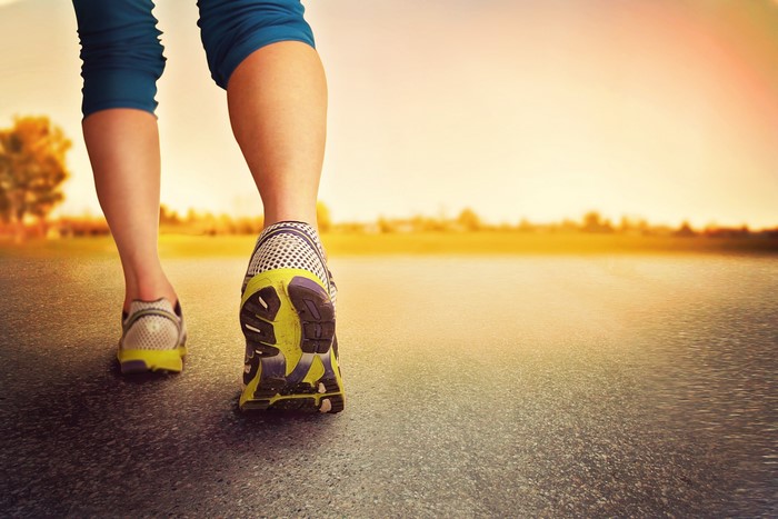 Person walking in athletic shoes on a road