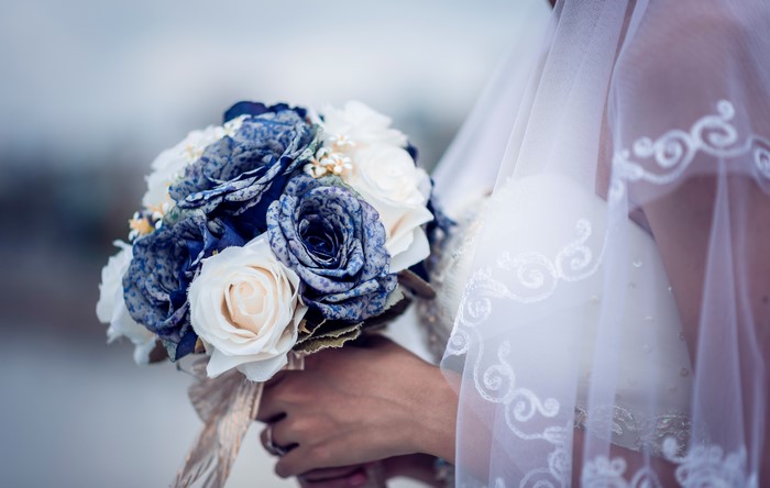 Bride holding a bouquet of blue and white roses