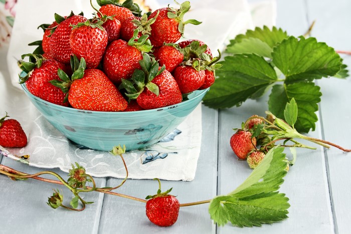 Strawberries in a bowl with leaves