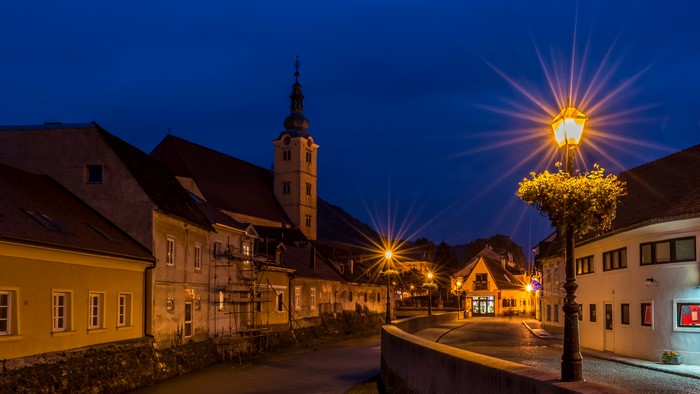 Night street in Samobor, Croatia with church tower and street lights