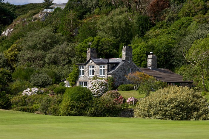 Stone house on a hill in Wales with green grass