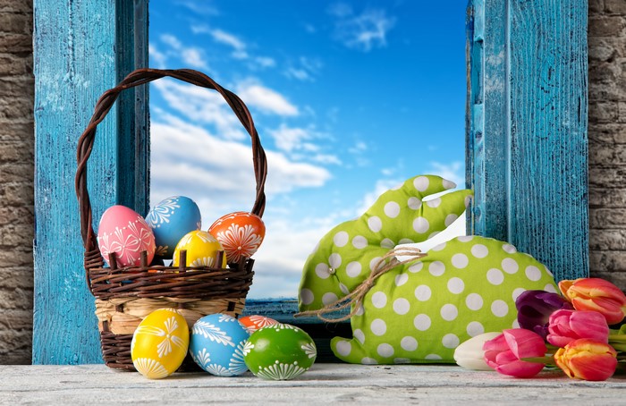 Easter eggs in a basket with a bunny and tulips