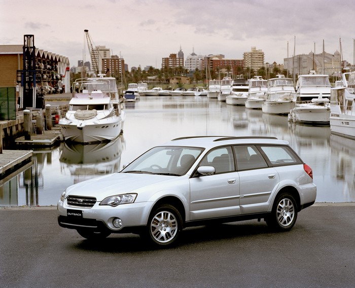 Silver Subaru Outback wagon parked by a marina
