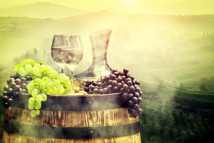 Wine and Grapes on a Barrel with Tuscan Landscape