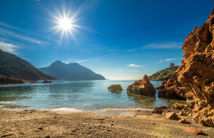 Coastal mountains and beach in Corsica, France under the sun