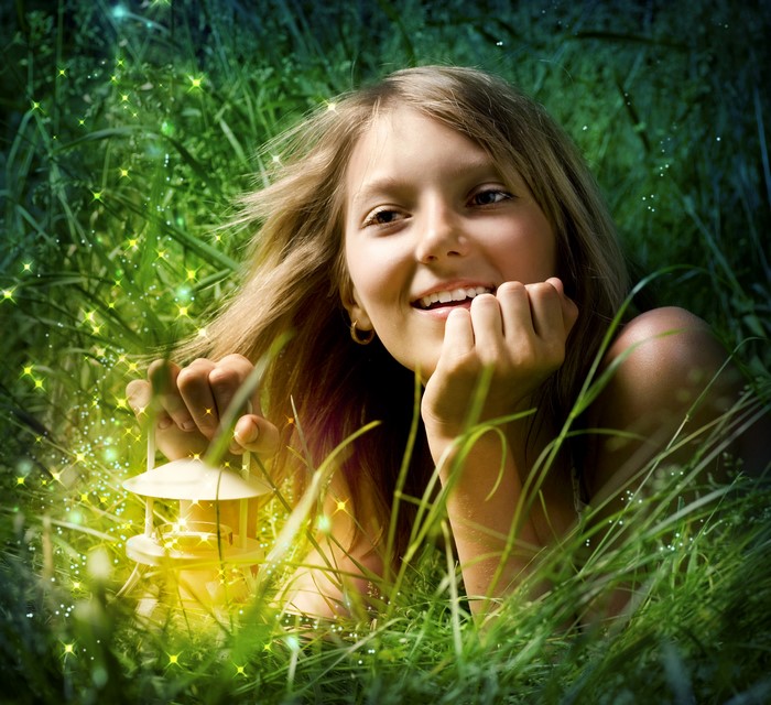 Girl with lantern in grass