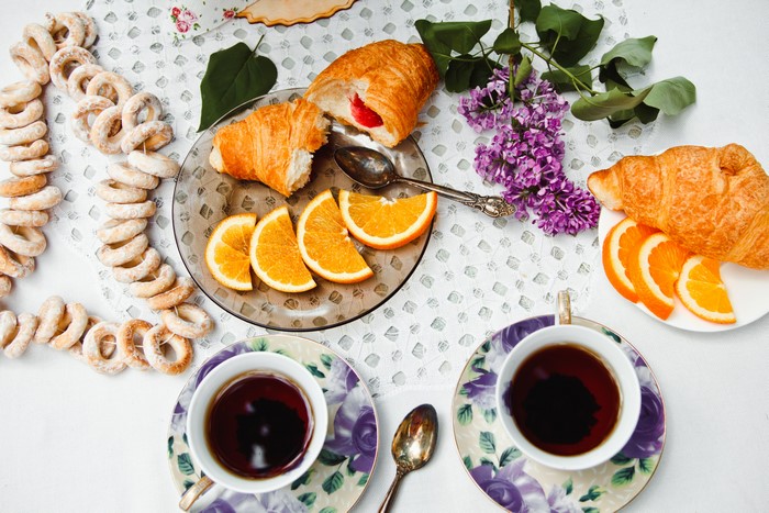 Still-life with Croissants, Oranges, Tea, and Lilac