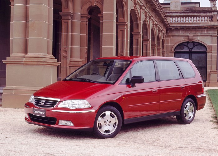 Red Honda Odyssey parked in front of a building