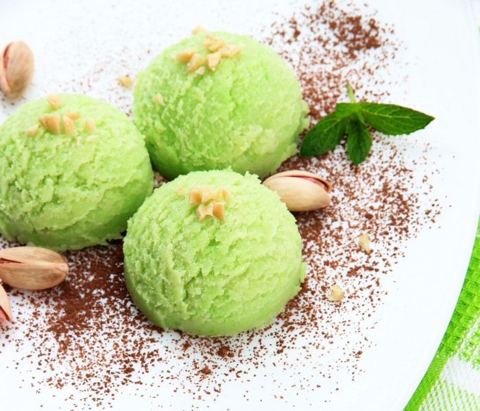 Pistachio ice cream scoops with pistachios and cocoa powder