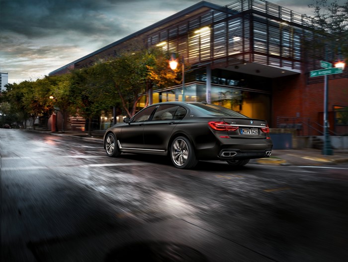 BMW M760Li xDrive driving on a wet city street