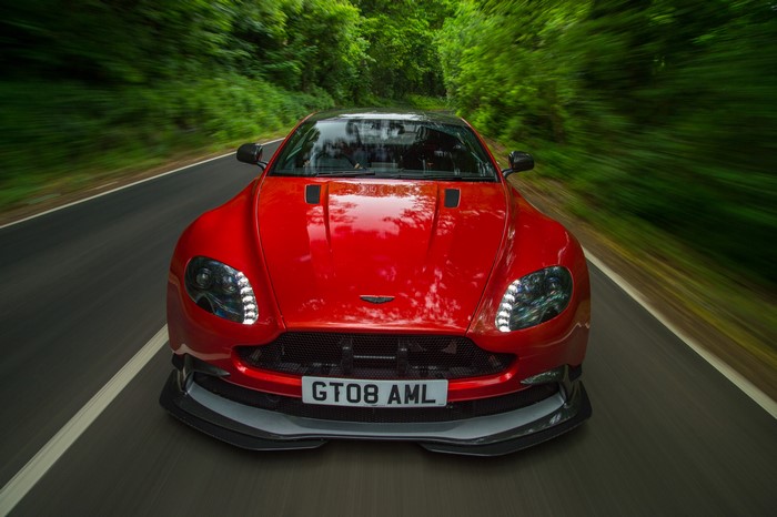 Red Aston Martin Vantage driving on a road