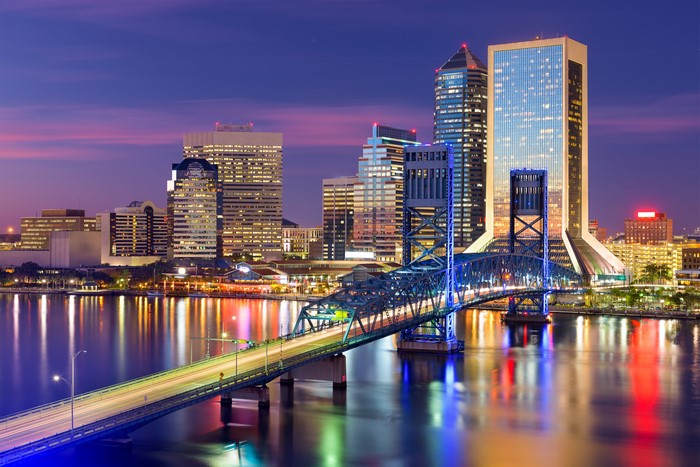 Jacksonville Florida skyline with bridge over river at dusk