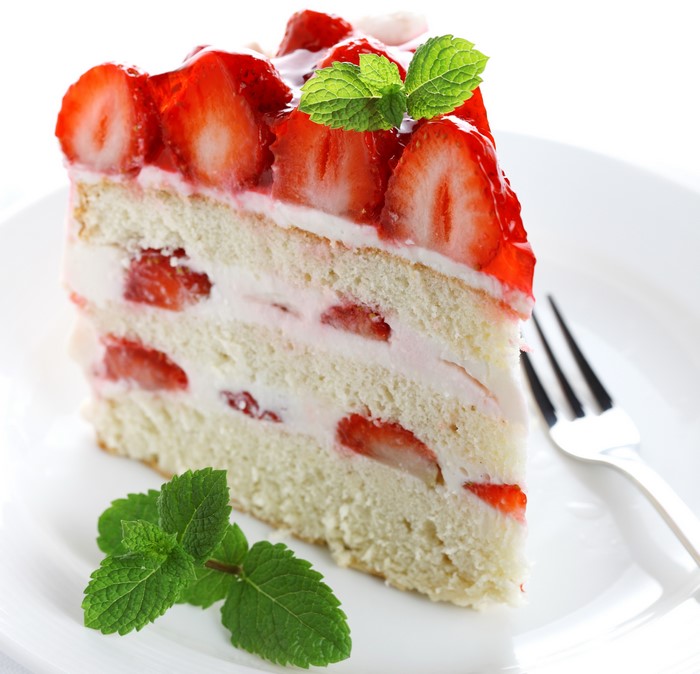 Slice of strawberry cake with mint garnish