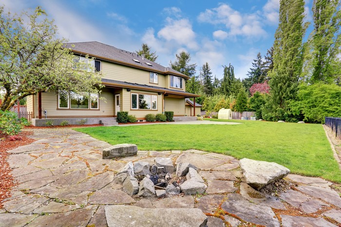 House with stone patio and fire pit