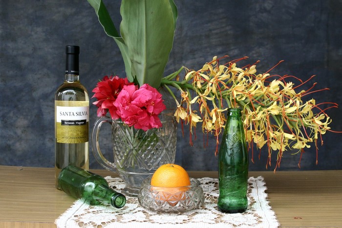 Still life with wine bottle, flowers, and orange