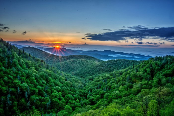 Sunrise over forested mountains with mist