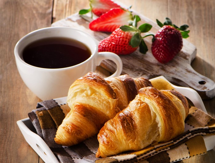 Croissants with coffee and strawberries
