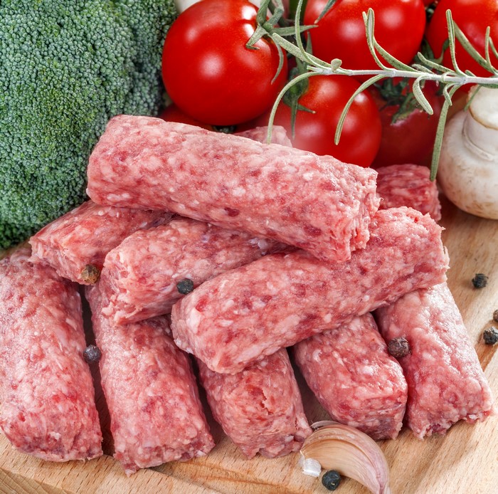 Raw sausages with broccoli, tomatoes, and garlic