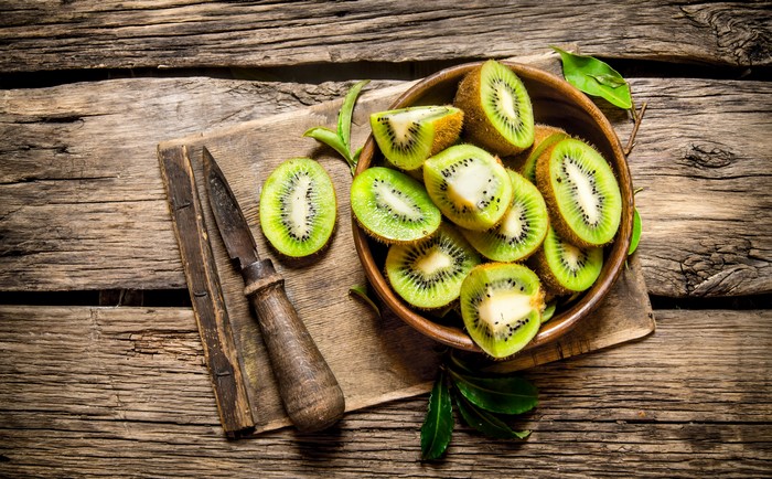Kiwi slices in a bowl with a knife