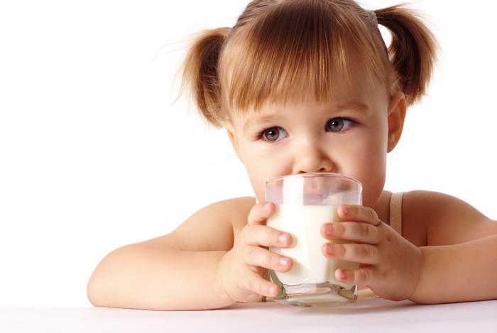 Little girl drinking milk from a glass