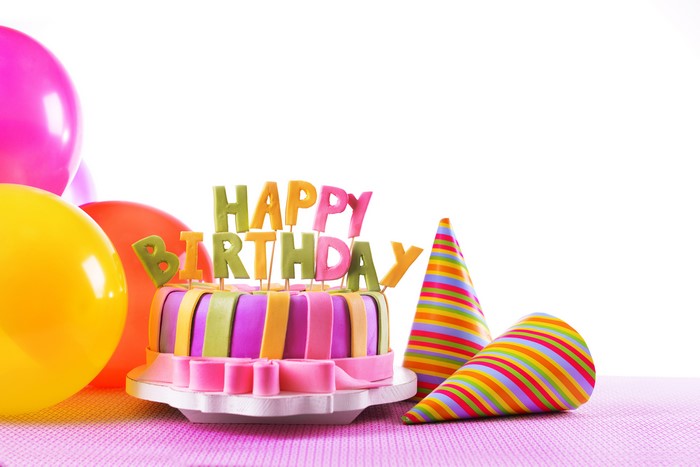 Birthday cake with balloons and party hats