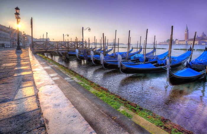 Gondolas docked in Venice canal at sunrise