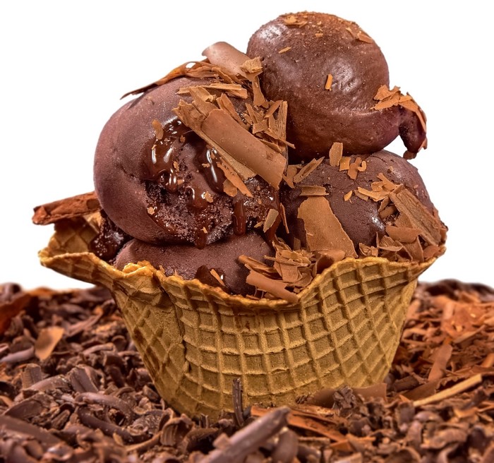 Chocolate ice cream scoops in a waffle cone with shavings