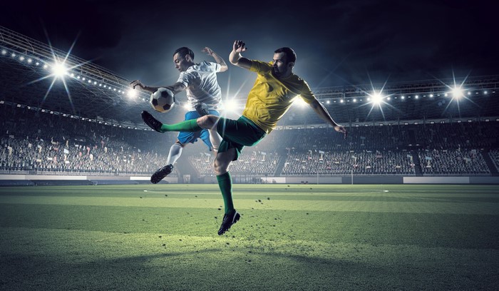 Two men playing soccer in a stadium