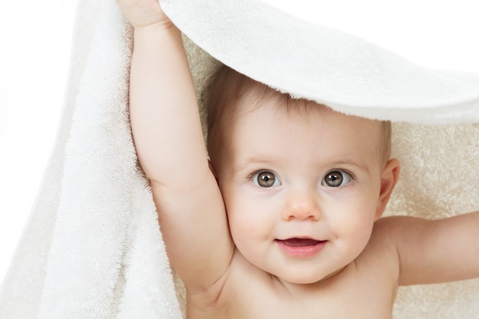 Baby peeking from under a towel